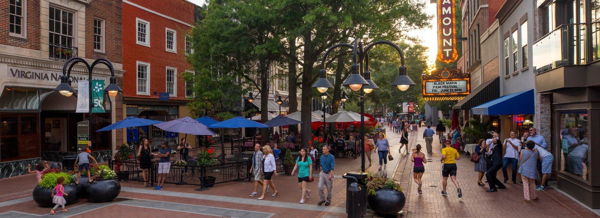 Downtown main street of a town with brick pathways, lined with shops and people milling around