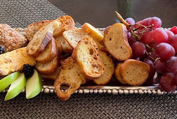 Silver platter with grapes, apples, berries and crostinis